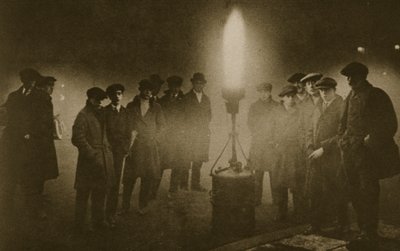 Gathering around an acetylene flare at traffic control point in the fog by English Photographer